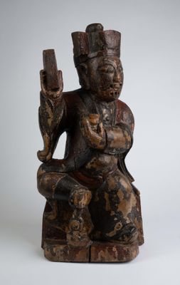 une image représentant une statue en bois d'un homme tenant un pistolet