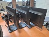 two computer monitors sitting on a desk in an office