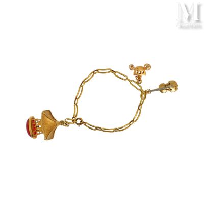 une photo d'un bracelet en or orné d'une clochette