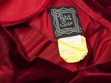 the back of a red dress with a black label on it