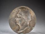 an old bronze coin with a man ' s face on it