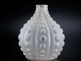 un gros plan d'un vase blanc posé sur une surface noire