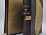 un vieux livre noir orné d'une bande dorée sur la couverture