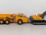 four toy construction vehicles that are lined up on the floor
