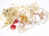 a pile of assorted necklaces and bracelets on a white surface