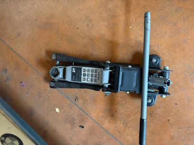 a broken cell phone sitting on the floor next to a pole