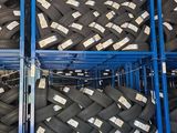 tires stacked on a rack in a warehouse with labels on them