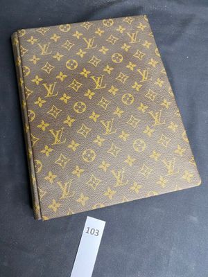 a louis vuitton notebook on a table with a price tag