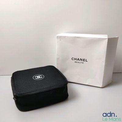 un étui noir orné du logo Chanel, à côté d'une boîte blanche