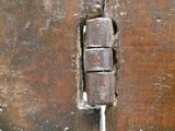 un gros plan sur un loquet métallique fixé à une porte en bois