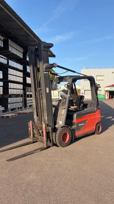 a red forklift truck parked in front of a building