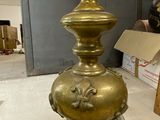 a gold vase sitting on the floor in a room