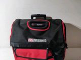 a red and black bag sitting on a white surface