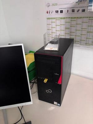 un ordinateur de bureau posé à côté d'un écran sur un bureau