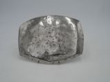 a close up of a silver ring on a white surface