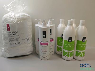 plusieurs flacons de lotion posés sur une table à côté d'un paquet de papier toilette