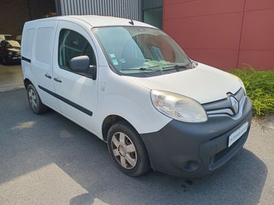 une petite camionnette blanche garée devant un bâtiment