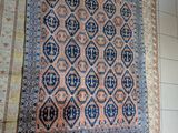 tapis accroché au mur d'une pièce dont le sol est carrelé