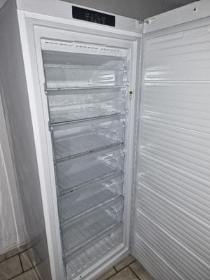 an image of an empty refrigerator in the corner of a room