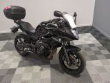 a black motorcycle parked in a room with a checkered floor