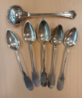 five spoons and a ladle sitting on a table