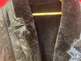 leather jacket on a hanger against a red wall
