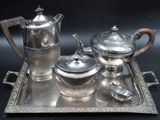 a silver tray with a silver tea set on it