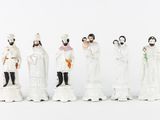 seven figurines of people dressed in white and black