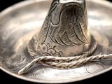 a silver plate with a silver bell on it