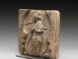 une image représentant un relief en pierre d'une femme tenant une fleur