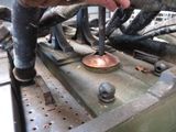 a man that is working on a machine with a hammer