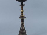 an antique bronze oil lamp with a bird on top of it