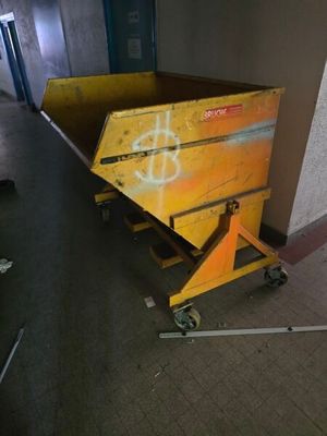 a yellow box sitting on top of a dolly in a hallway