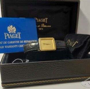 une boîte noire contenant une montre en or et une carte bleue