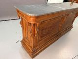 a wooden desk with a marble top on a white floor