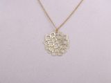 a gold plated necklace with a geometric design on a mannequin