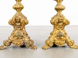 pair of antique brass candlesticks with ornate designs on bases