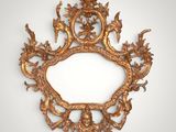 an ornate gold mirror with a bird and flower design