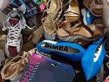 un sac rempli de chaussures et un livre par terre