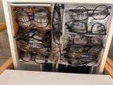 many pairs of glasses sitting in a drawer