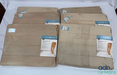 quatre paires de collants beiges sont posées sur une nappe blanche