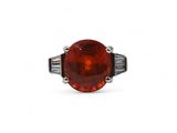 une bague en pierre rouge ornée d'une rangée de diamants en taille baguette au centre