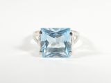 une photo d'une bague en topaze bleue sertie d'un diamant au centre