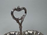 a silver plate with a heart shaped handle on it