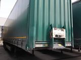 deux semi-remorques vertes garées sur un parking
