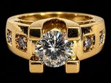 a close up of a gold ring with a diamond in the center