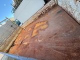 a rusted bed in the back yard of a house