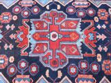 an image of a blue and red oriental rug on a wooden floor