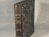 an old book sitting on top of a table next to a gray background