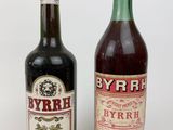 two bottles of wine sitting next to each other on a white surface
